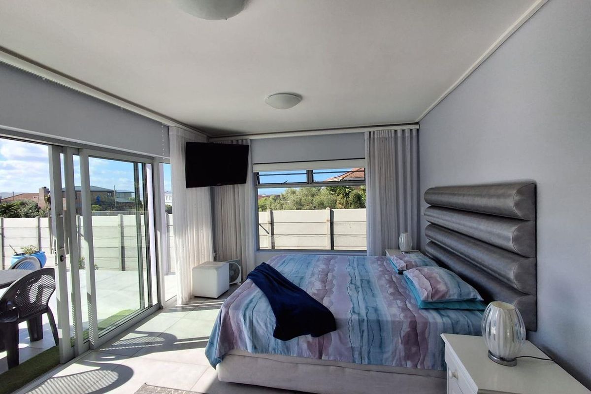 A bright and spacious bedroom featuring large sliding glass doors that provide natural light and direct access to the outdoor patio area.