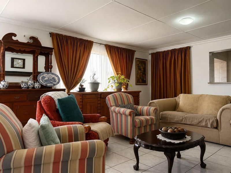 A comfortable living room featuring tiled flooring and a classic ceiling finish, providing a functional and traditional space for relaxation.