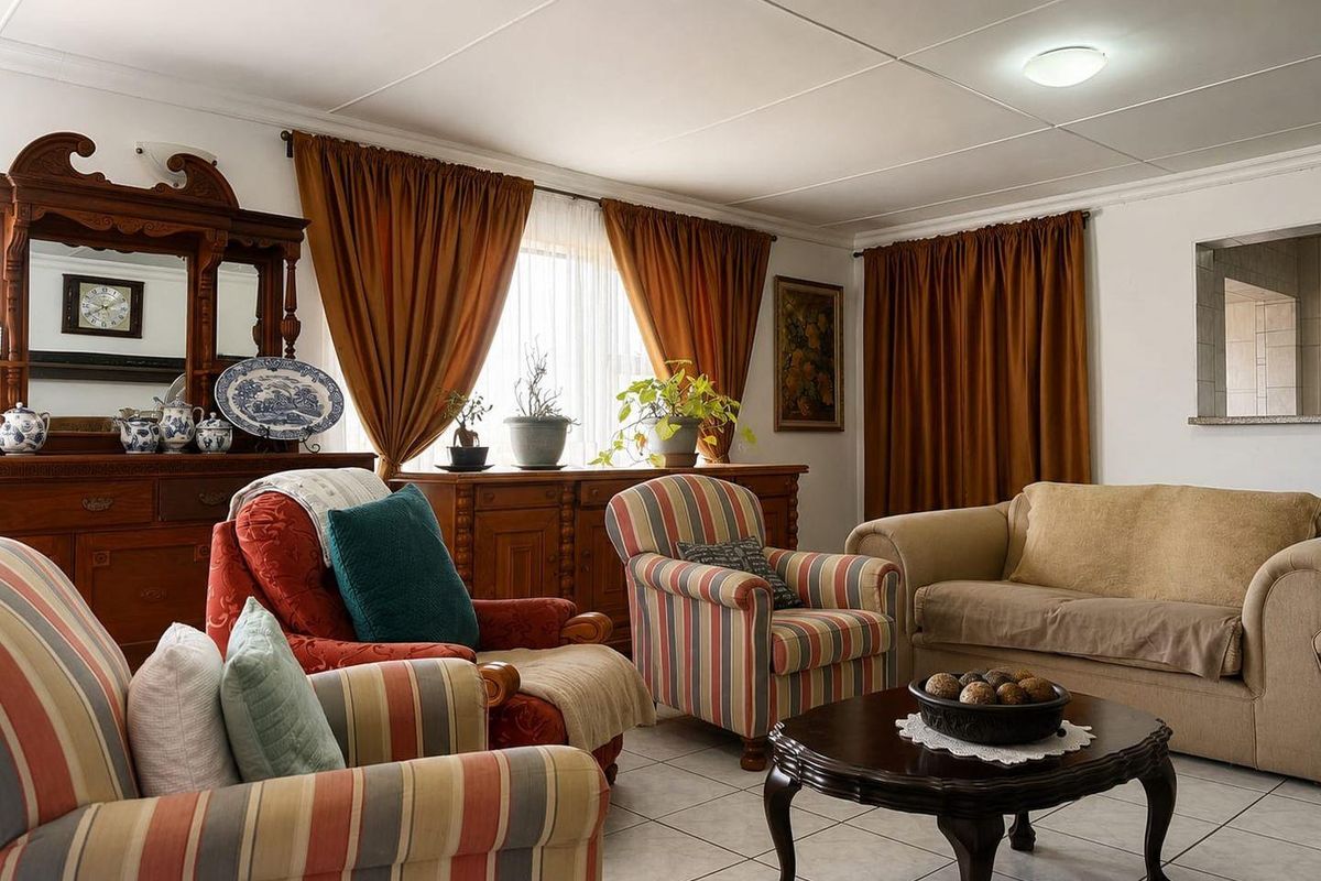 A comfortable living room featuring tiled flooring and a classic ceiling finish, providing a functional and traditional space for relaxation.