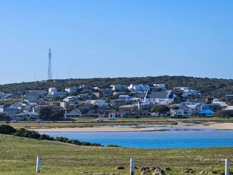 A scenic landscape view overlooking a coastal residential area, lagoon, and surrounding natural vegetation.