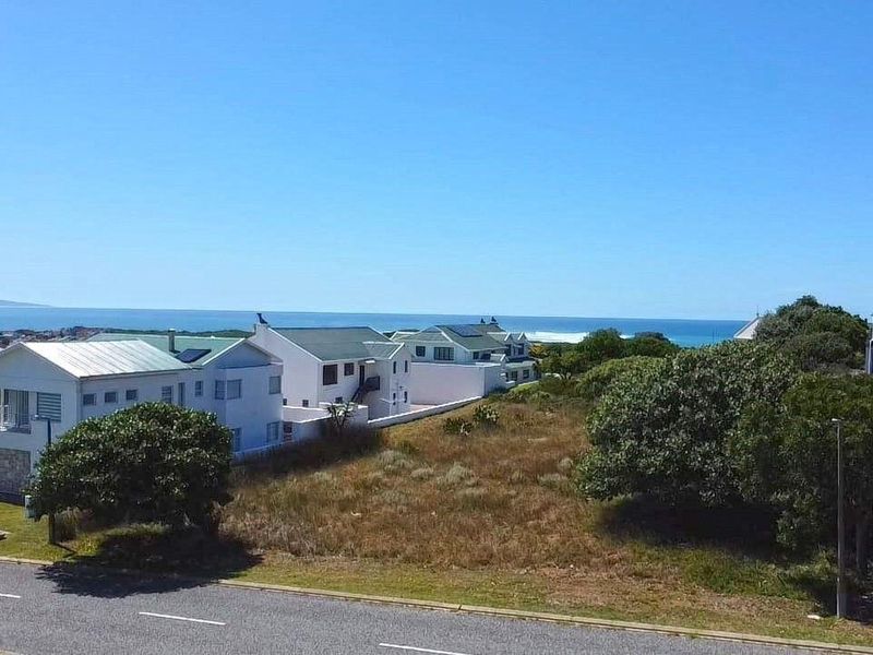 An elevated aerial view of a vacant residential plot situated in a coastal neighborhood with ocean views.
