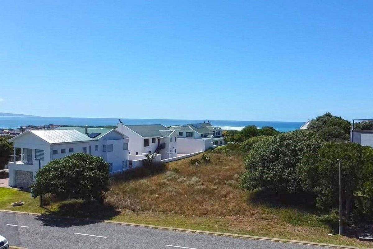 An elevated aerial view of a vacant residential plot situated in a coastal neighborhood with ocean views.