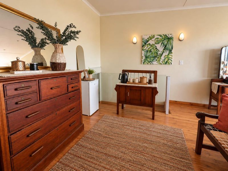 A well-maintained living area featuring warm hardwood flooring, a modern glass balustrade, and elegant wall sconce lighting.