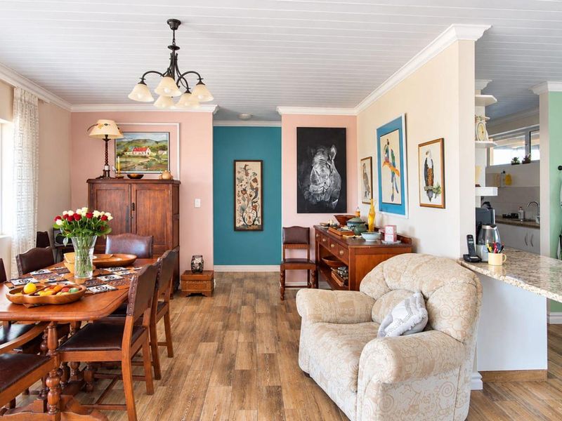 Spacious open-plan living and dining area featuring timber-look flooring, tongue and groove ceilings, and a functional kitchen with granite countertops.