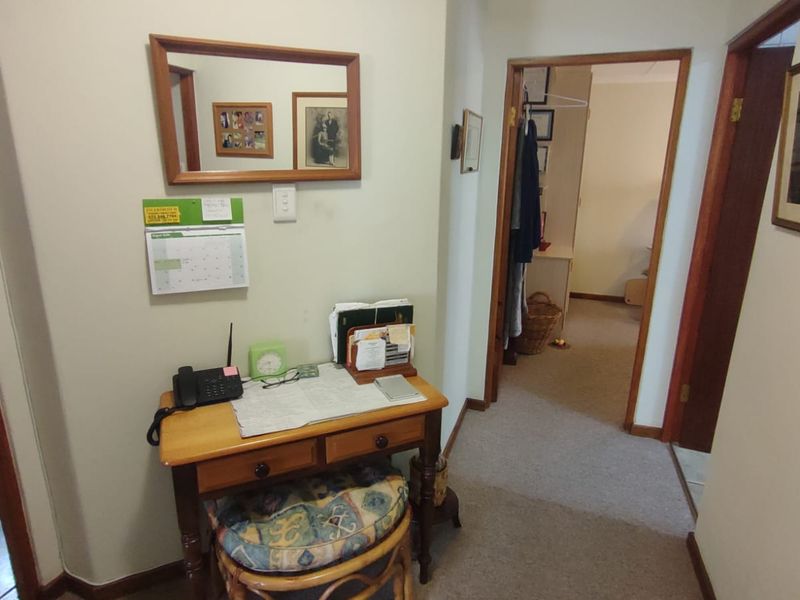 A functional hallway area connecting multiple rooms, featuring carpeted flooring and traditional wooden door frames.