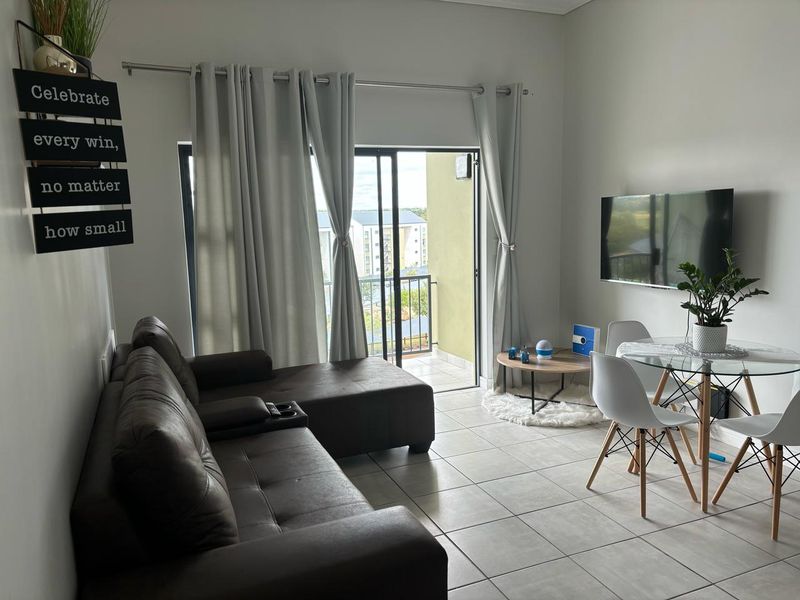 Open-plan living and dining area featuring tiled flooring and direct access to a private balcony through sliding glass doors.