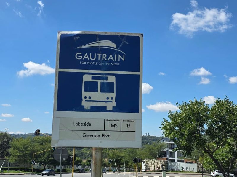 A Gautrain bus stop sign located on Greenlee Boulevard, indicating proximity to public transport infrastructure.