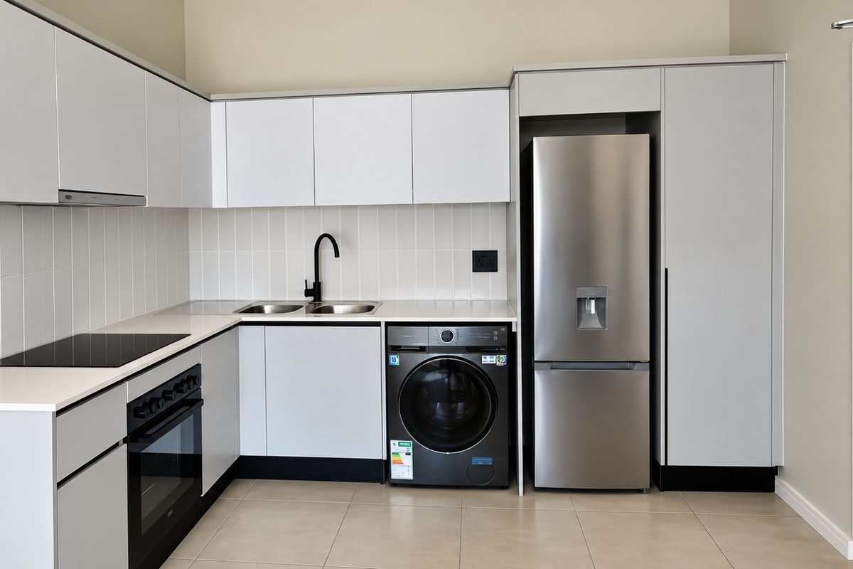 Modern kitchen featuring sleek white cabinetry, quartz countertops, integrated appliances, and a tiled backsplash in a clean, contemporary finish.