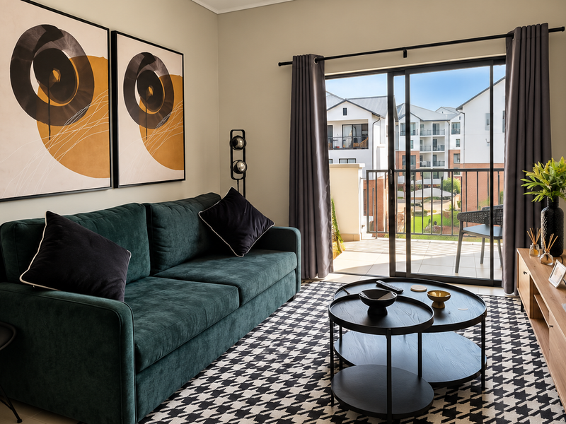 A well-maintained living room featuring a sliding glass door that opens onto a balcony, providing natural light and access to outdoor space.