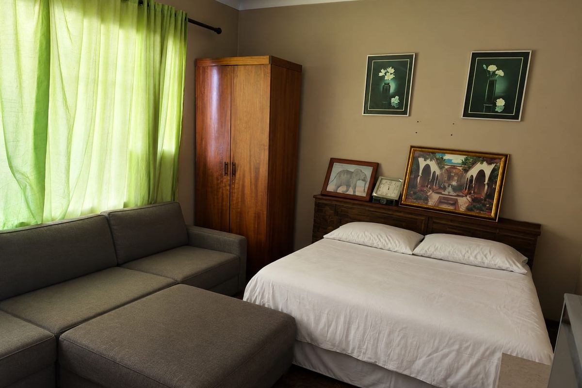 A functional bedroom featuring neutral wall tones and cove cornicing, providing a comfortable and well-proportioned sleeping space.