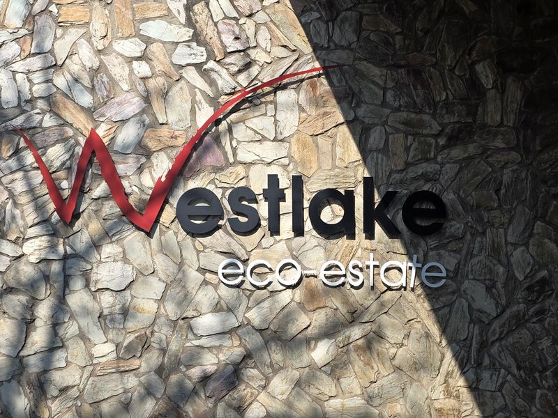 A close-up view of the Westlake Eco-Estate entrance signage mounted on a decorative stone-clad feature wall.