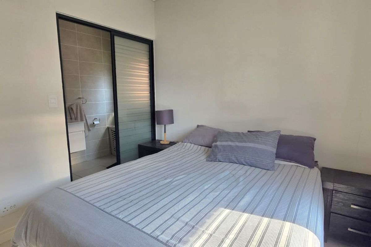 A well-maintained bedroom featuring a sliding glass door providing direct access to an en-suite bathroom.