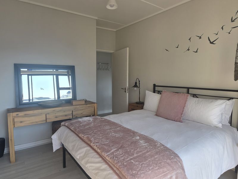 A well-maintained bedroom featuring laminate flooring, neutral wall finishes, and a built-in cupboard, offering a comfortable and functional living space.