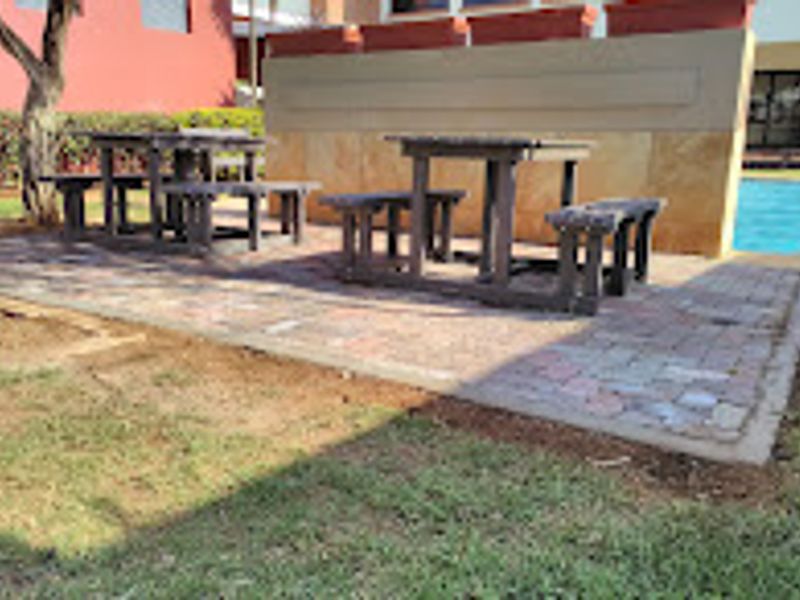 Outdoor pool area featuring a paved patio space, retaining wall, and access to the swimming pool.