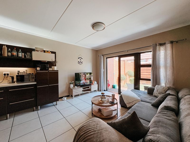 Open plan living area featuring tiled flooring, built-in cabinetry, and large sliding glass doors providing access to an outdoor patio area.