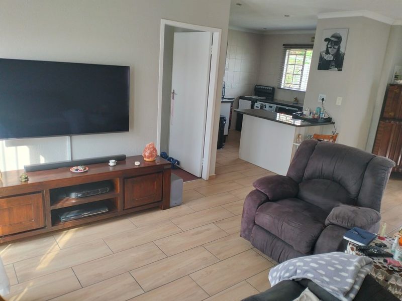 Open plan living area featuring tiled flooring, recessed lighting, and a functional kitchen with a breakfast bar counter.
