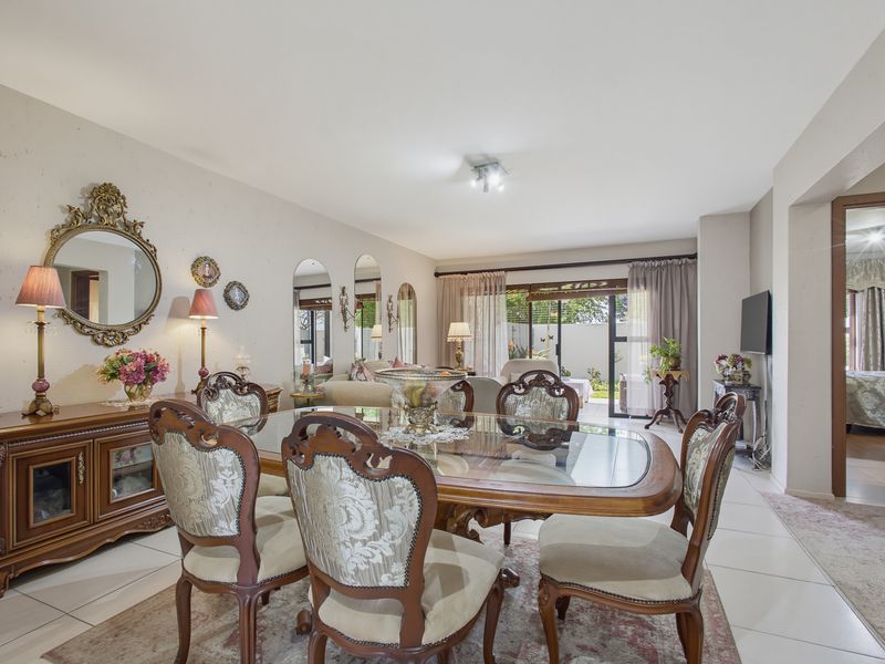 Spacious dining area featuring neutral tiled flooring and large sliding glass doors that provide natural light and access to the outdoor patio.