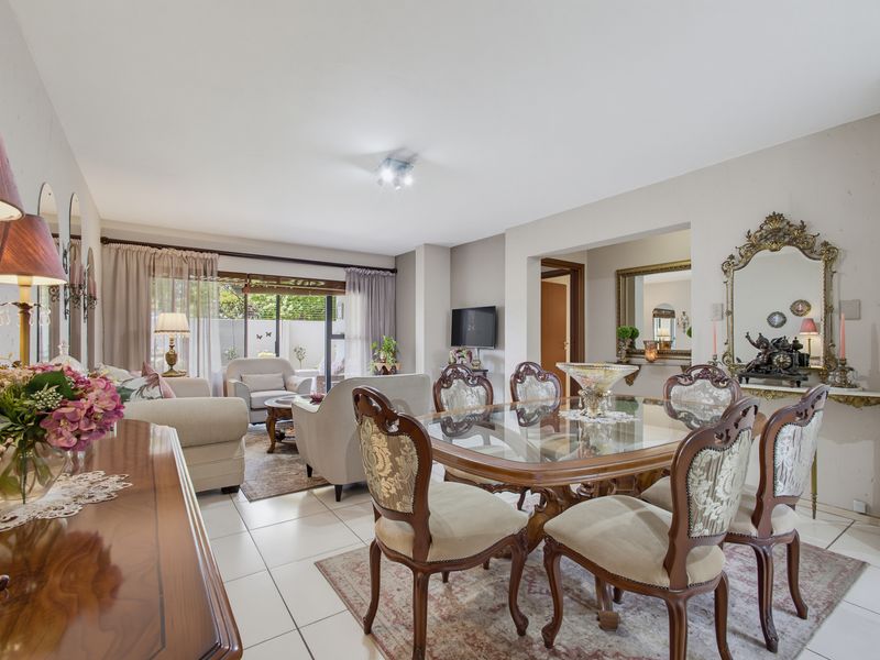 Spacious open-plan living and dining area featuring neutral tiled flooring and large sliding glass doors leading to an outdoor space.