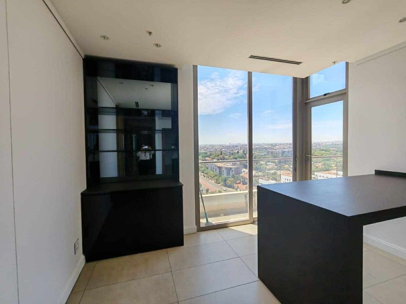 Modern open-plan living area featuring sleek built-in cabinetry, floor-to-ceiling windows with expansive city views, and neutral tiled flooring.