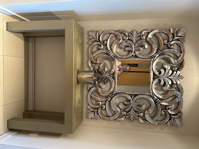 A small entryway area featuring neutral tiled flooring and a wall-mounted electrical outlet.