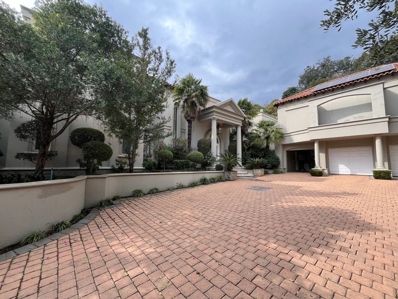 Front elevation of a cluster home featuring a paved driveway, covered portico entrance, and integrated garage with solar panels on the roof.