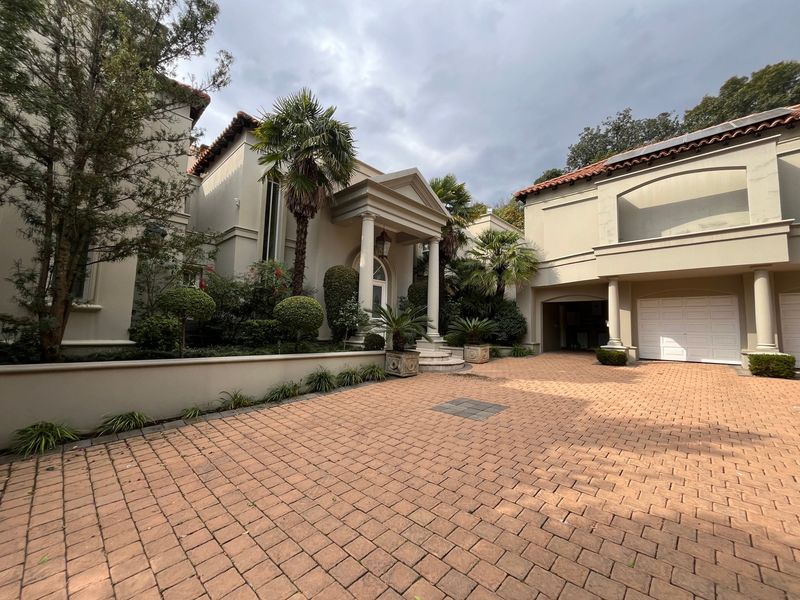 Front elevation of a cluster home featuring a paved driveway, grand portico entrance with columns, and an integrated garage.