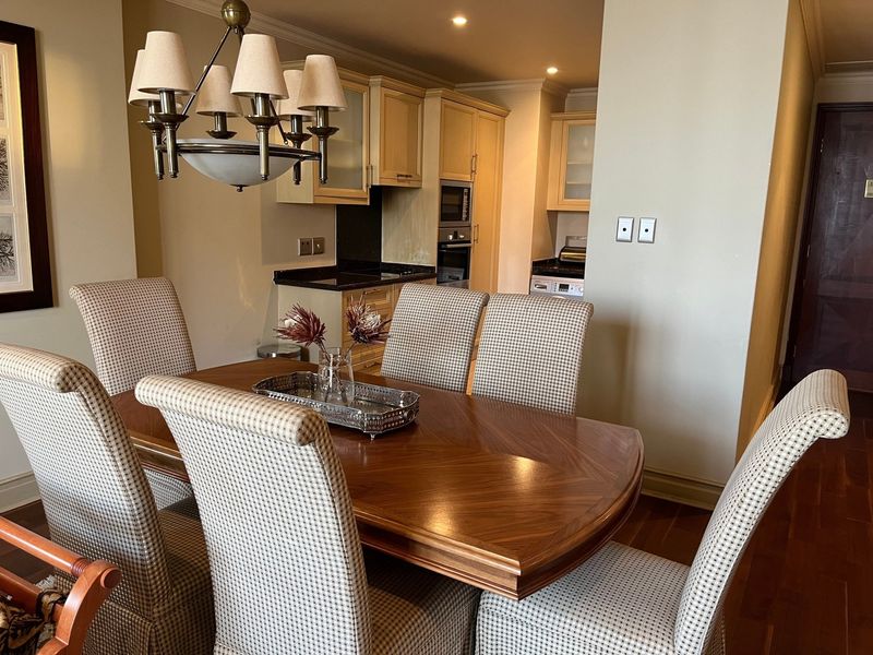 Open plan dining area adjacent to a functional kitchen featuring built-in cabinetry, granite countertops, and integrated appliances.