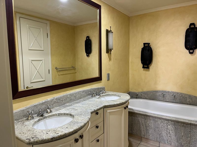 Spacious bathroom featuring a double vanity with granite countertops, undermount sinks, and a built-in bathtub with matching granite surround.