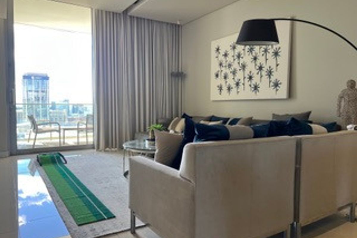 Modern living room featuring large sliding glass doors leading to a balcony, neutral tiled flooring, and recessed ceiling lighting.