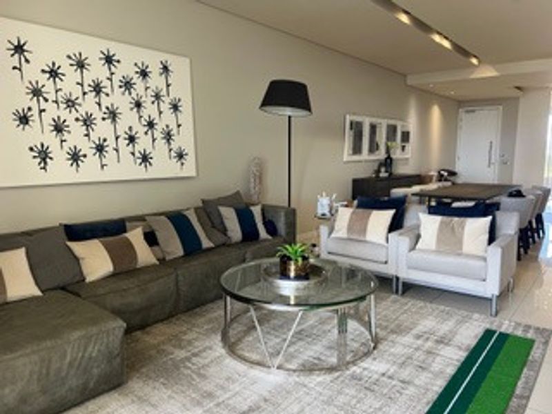 A spacious open-plan living and dining area featuring modern recessed ceiling lighting and neutral tiled flooring throughout.