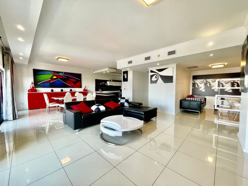 Spacious open-plan living and dining area featuring polished porcelain floor tiles, recessed lighting, and integrated ducted air conditioning throughout.