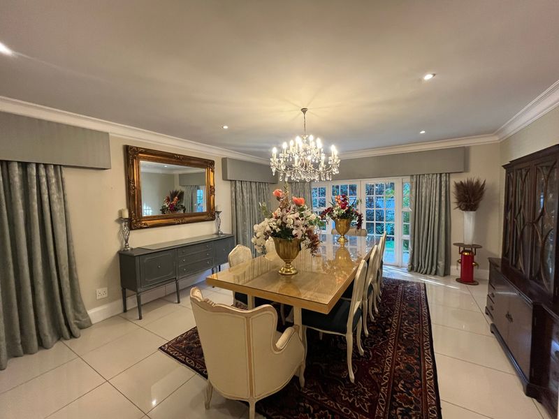 Elegant dining room featuring polished tiled flooring, recessed downlighting, crown molding, and classic french doors leading to the exterior.