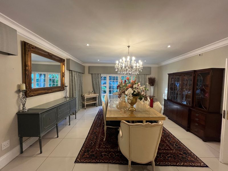 Spacious dining room featuring polished tile flooring, elegant crown molding, recessed lighting, and classic French doors leading to the exterior.