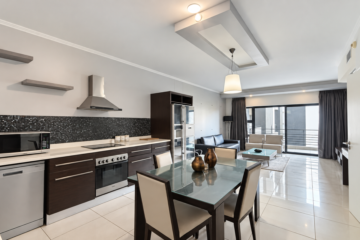 Modern open-plan kitchen and living area featuring dark wood cabinetry, mosaic backsplash, stainless steel appliances, and large sliding doors leading to a balcony.