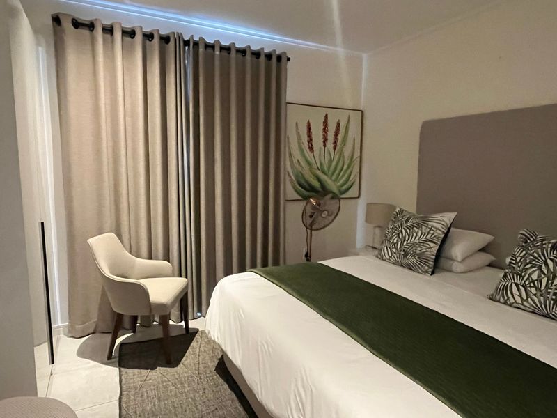 A well-maintained bedroom featuring tiled flooring and floor-to-ceiling curtains, providing a comfortable and functional living space.