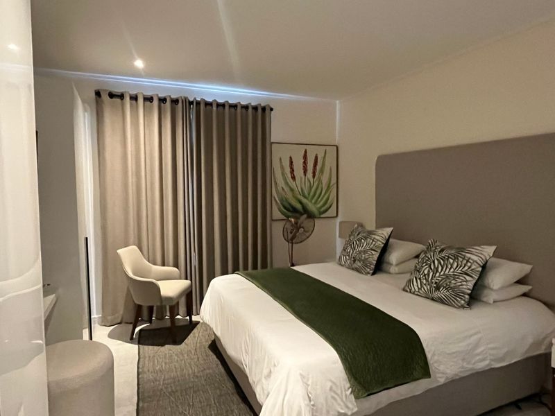 A well-maintained bedroom featuring a built-in wardrobe, recessed lighting, and large sliding doors leading to an outdoor area.