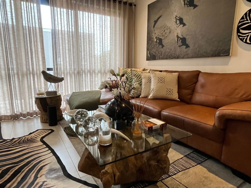A well-maintained living room featuring tiled flooring and large sliding glass doors that provide ample natural light.