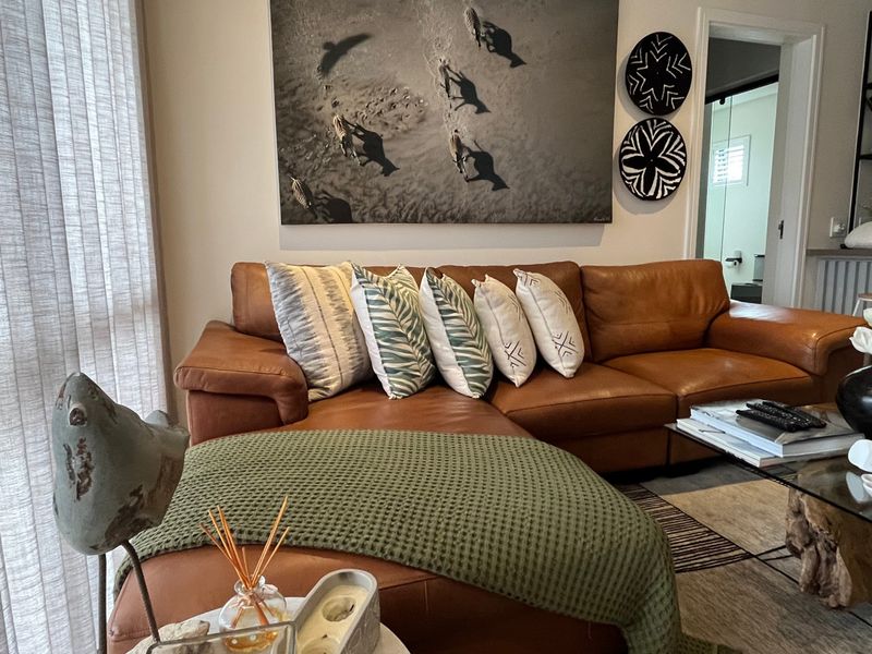 A well-maintained living room featuring neutral walls, modern recessed lighting, and a large sliding glass door providing natural light.