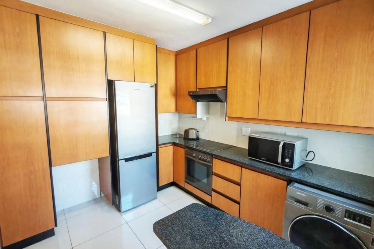 A functional kitchen featuring wood-finish cabinetry, granite countertops, and integrated appliances, offering a practical layout for daily cooking and meal preparation.