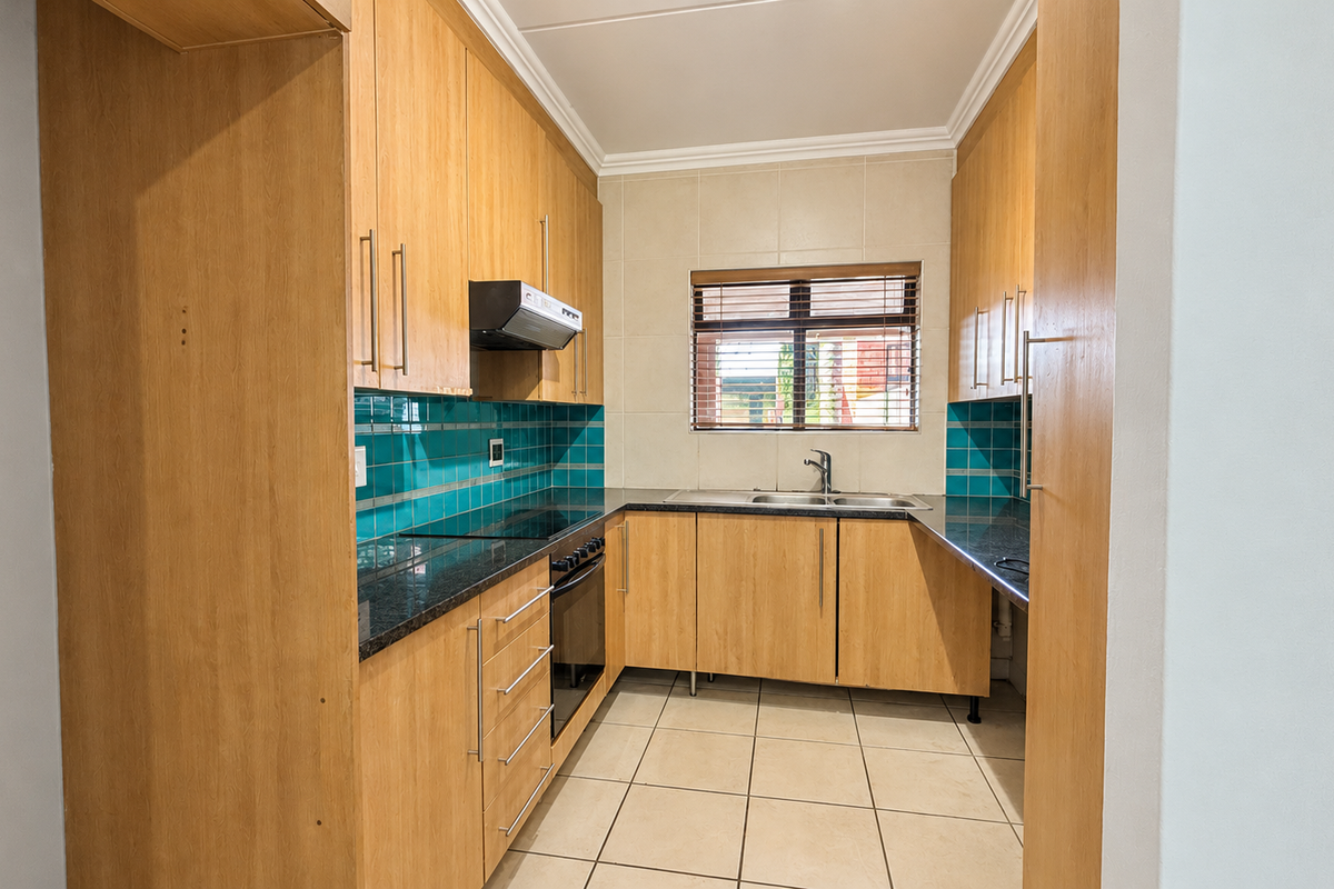 A functional kitchen featuring light wood cabinetry, granite countertops, a tiled backsplash, and integrated appliances including an oven and hob.