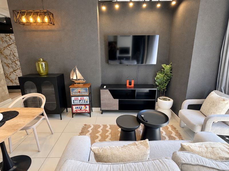 A modern open-plan living area featuring a textured feature wall, tiled flooring, and integrated lighting, creating a contemporary and inviting space.