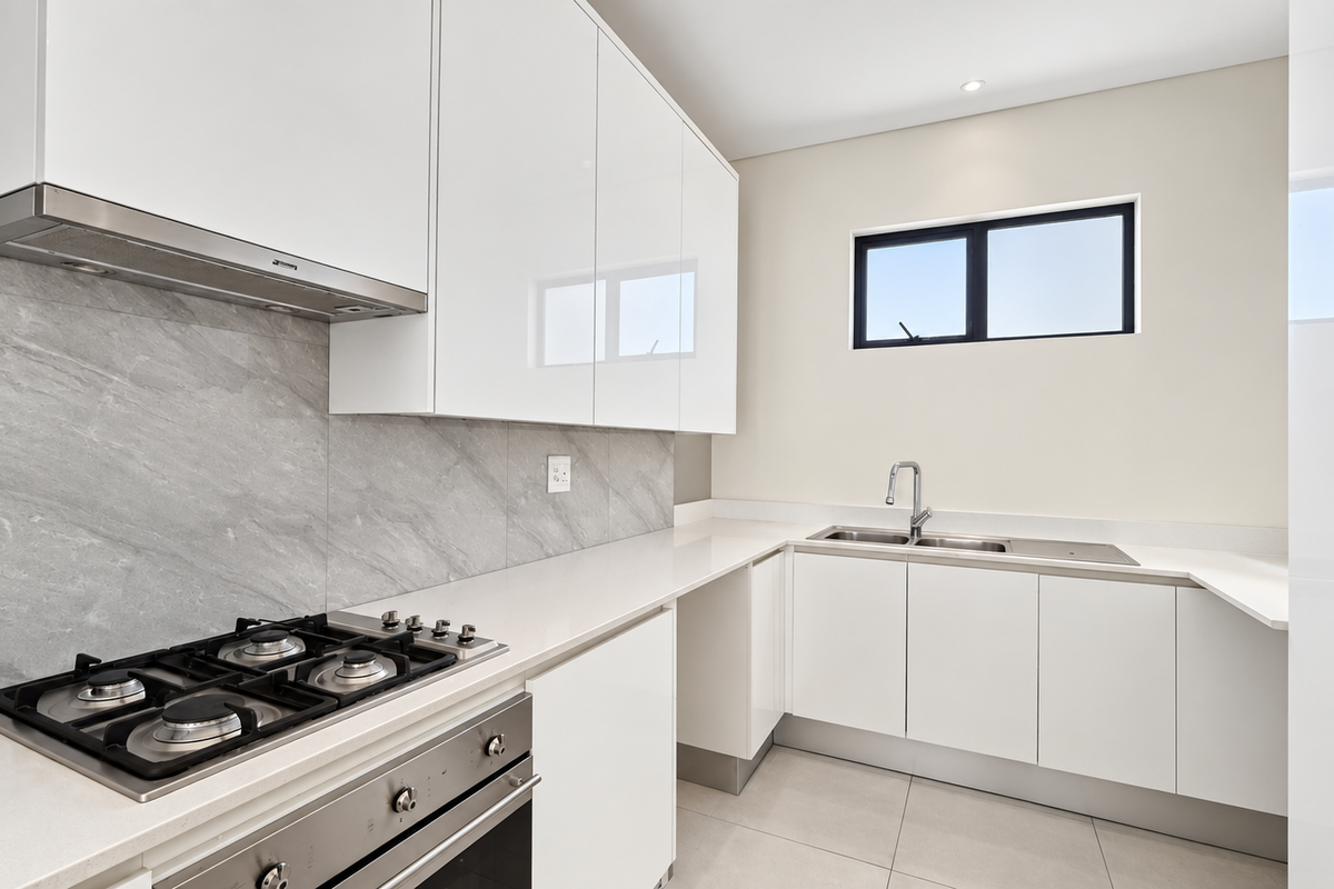 Modern kitchen featuring high-gloss white cabinetry, stone countertops, a gas cooktop with extractor, and a double bowl sink with a sleek mixer tap.