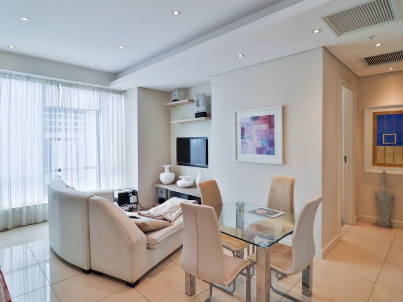 Modern open-plan living and dining area featuring tiled flooring, recessed lighting, ducted air conditioning, and built-in shelving.