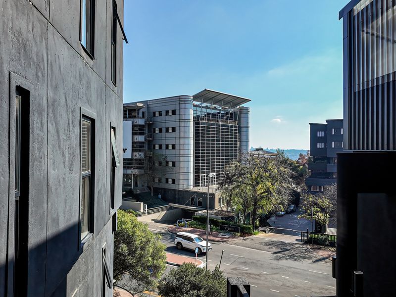 An elevated urban view overlooking a street and surrounding commercial architecture, showcasing the property's location and neighborhood context.