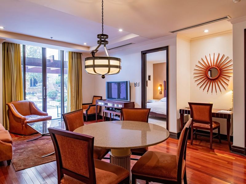 Spacious open-plan living and dining area featuring rich hardwood flooring, recessed lighting, and direct access to an outdoor patio through sliding glass doors.