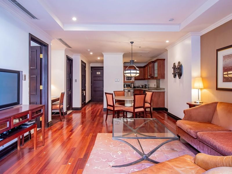 Spacious open-plan living and dining area featuring polished hardwood flooring, recessed lighting, and a functional kitchen with built-in cabinetry.