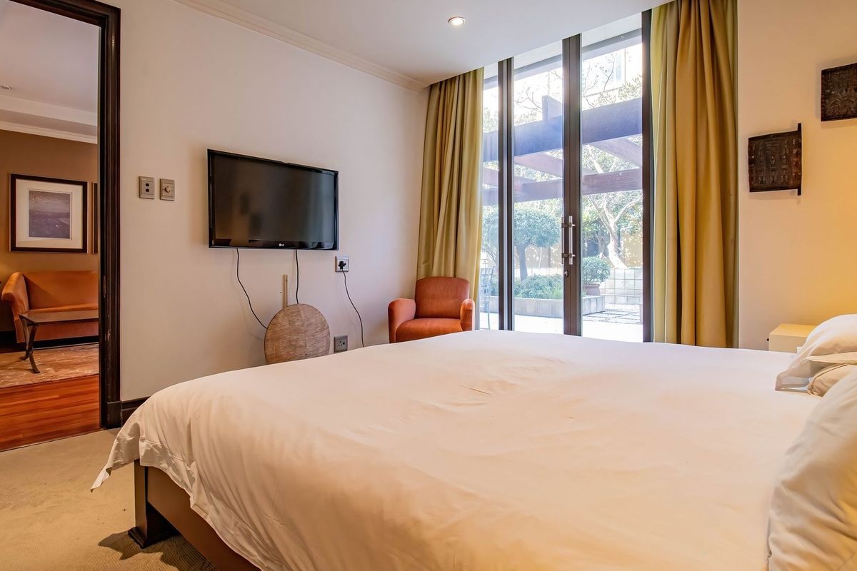 Spacious bedroom featuring carpeted flooring, recessed lighting, and sliding glass doors providing direct access to an outdoor patio area.