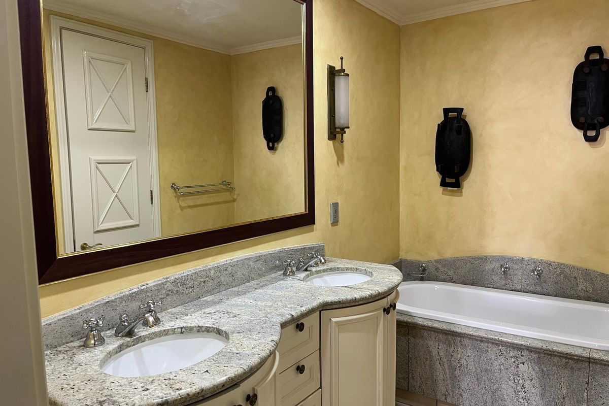 Spacious bathroom featuring a double vanity with granite countertops, undermount sinks, and a built-in bathtub with matching granite surround.