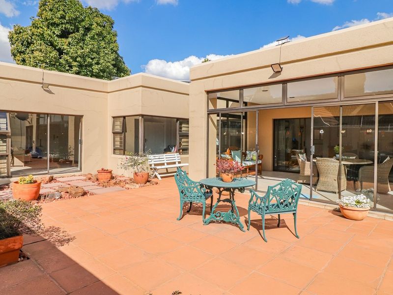 A spacious rear patio featuring terracotta tiling and large sliding glass doors that provide seamless access to the interior living spaces.