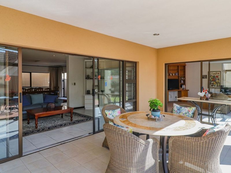 A covered patio area featuring tiled flooring and large sliding glass doors that provide seamless access to the interior living spaces.